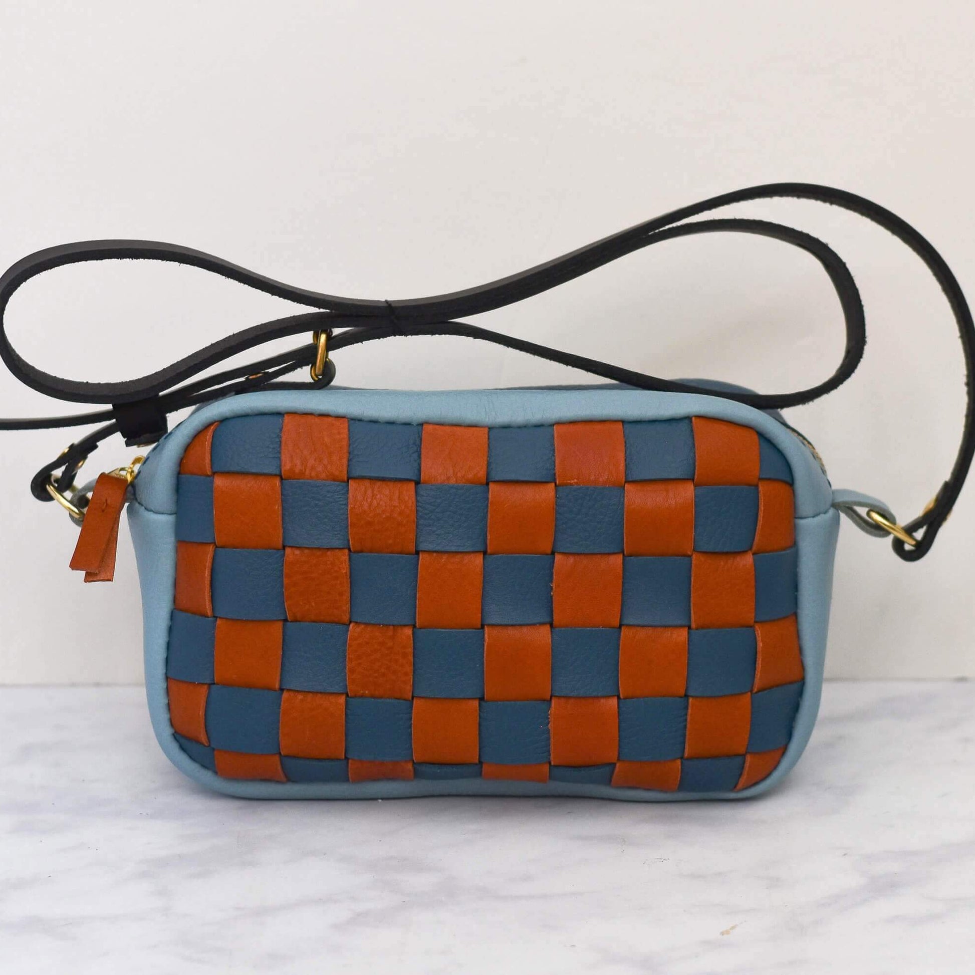 Woven checkered bag with blue and brown pattern on a white background