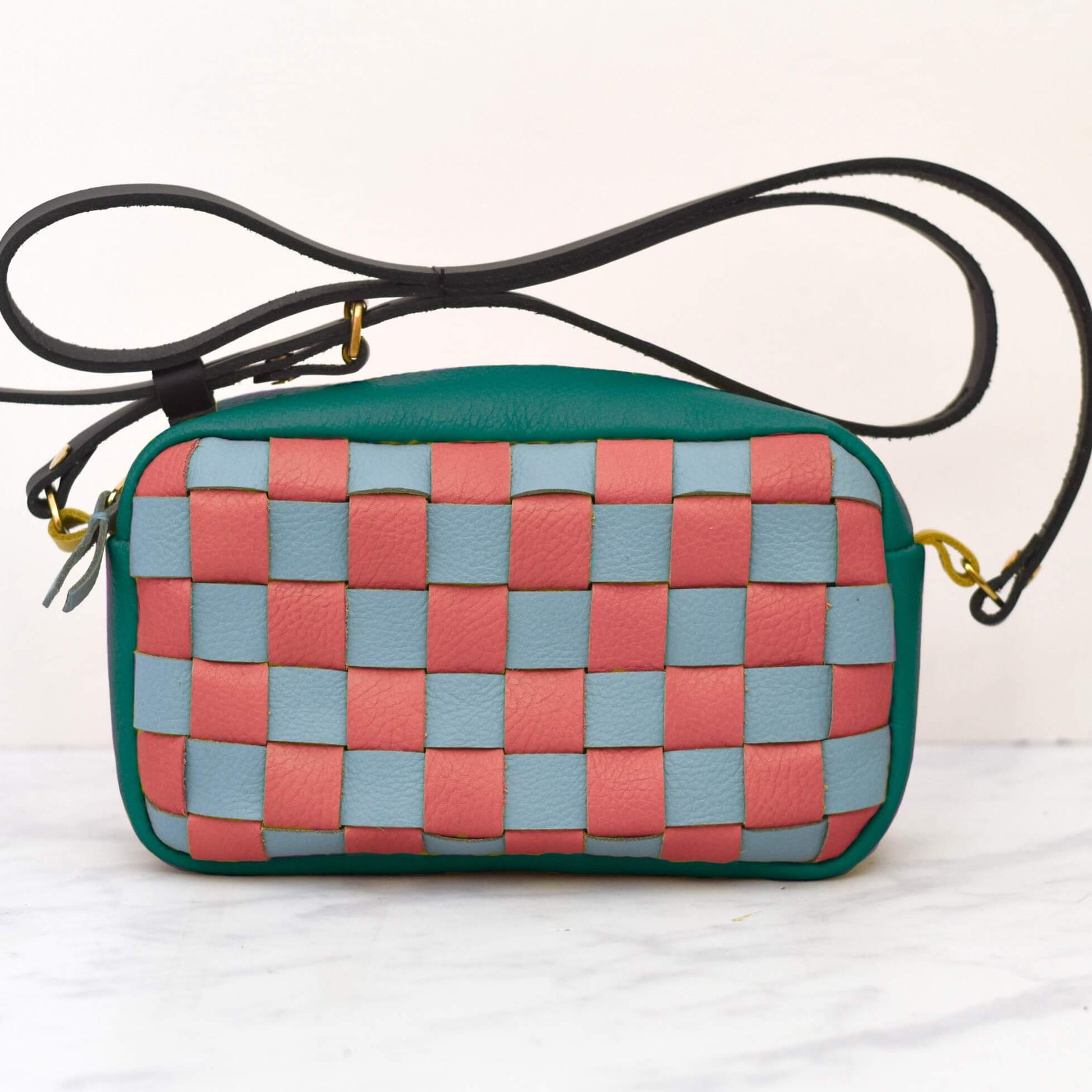 Woven handbag with pink and blue pattern on a white background