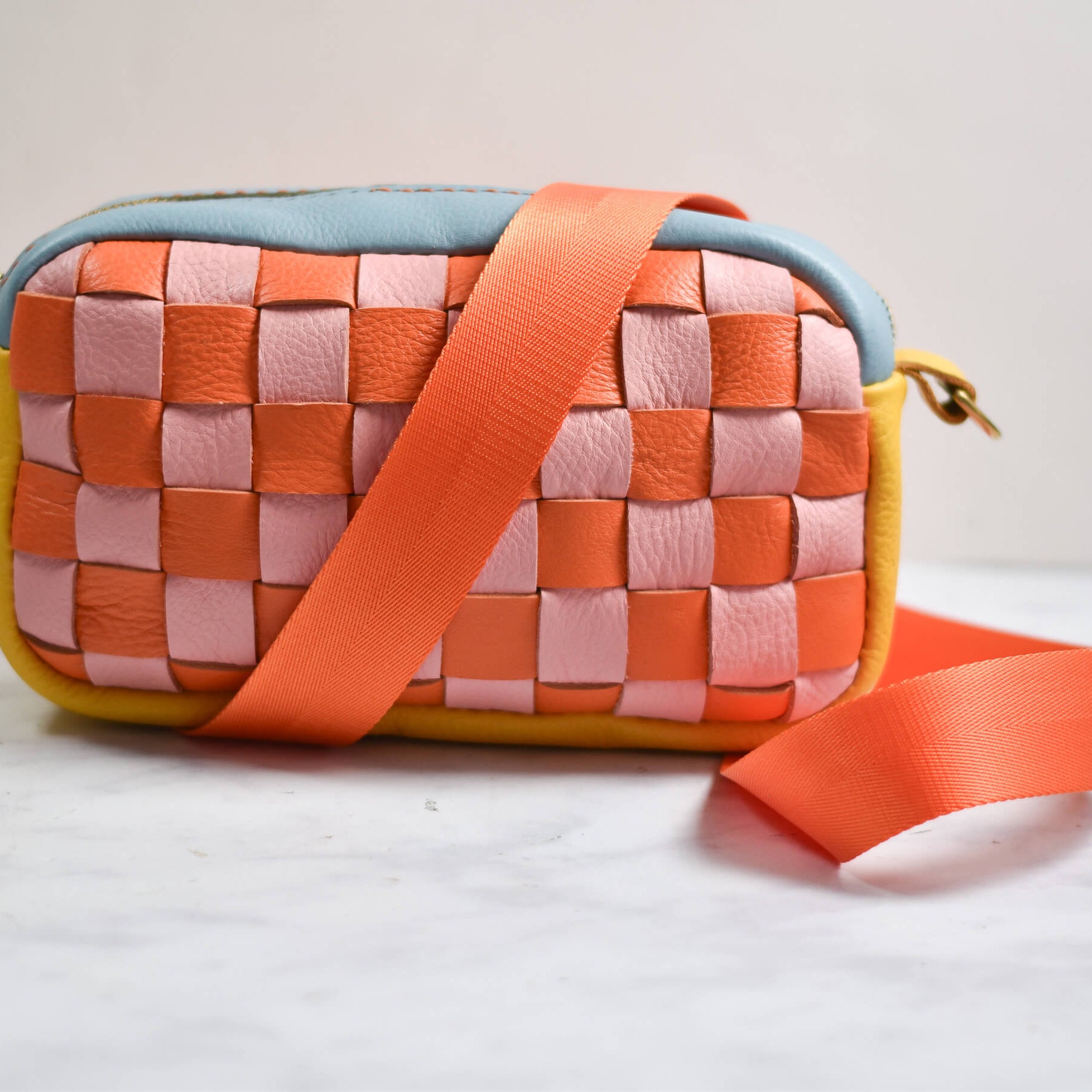 Woven handbag with a strap on a light background