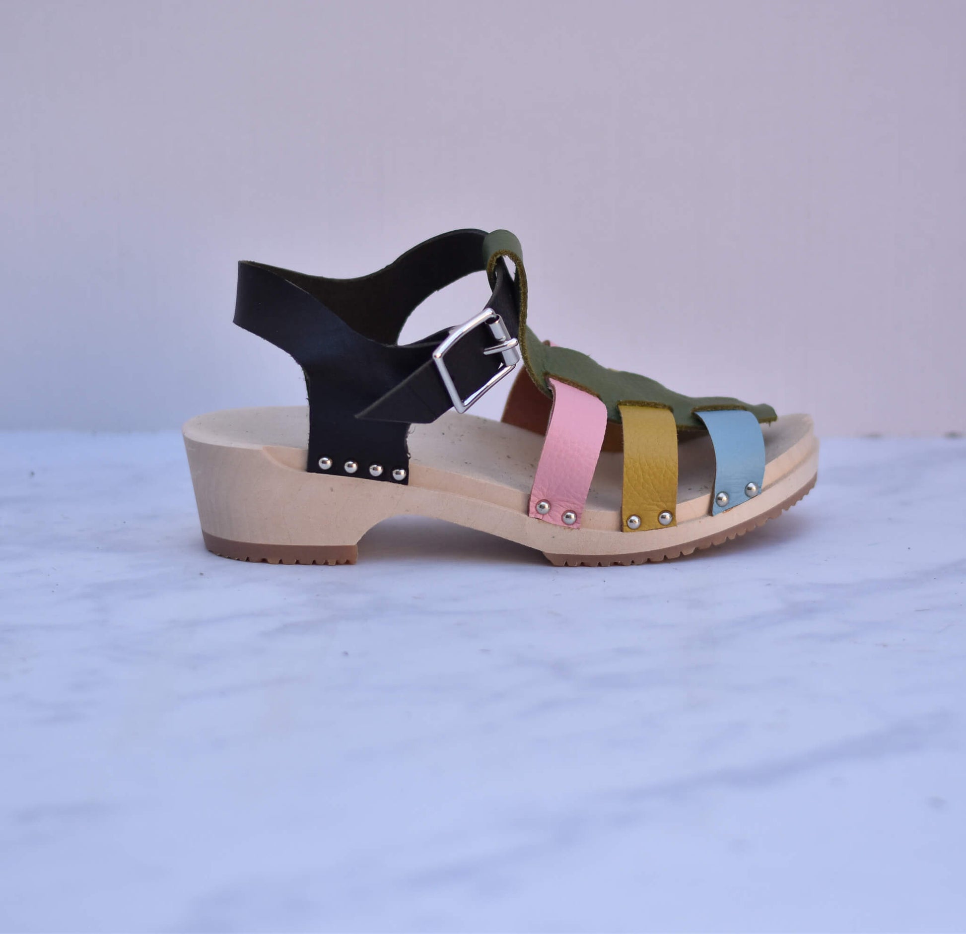 Colorful sandal with wooden sole on a light gray background