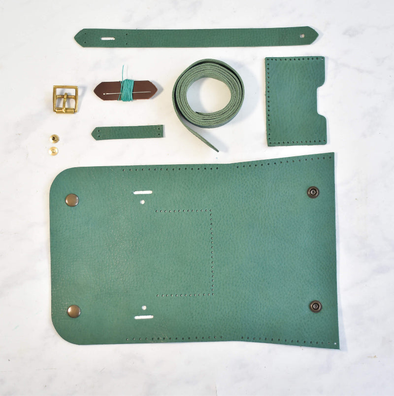 Green leather wallet components on a white background