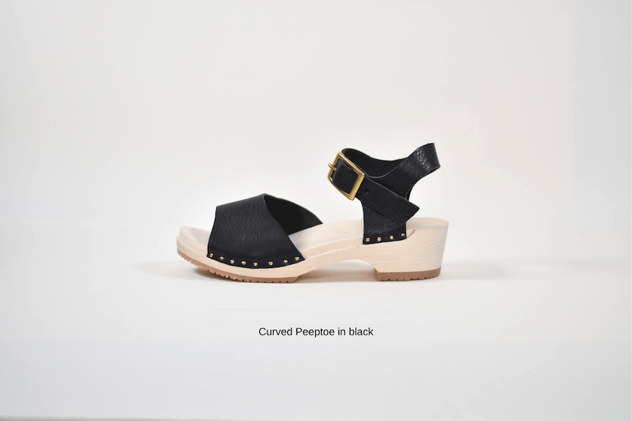 Black sandal with wooden sole made from a kit on a white background