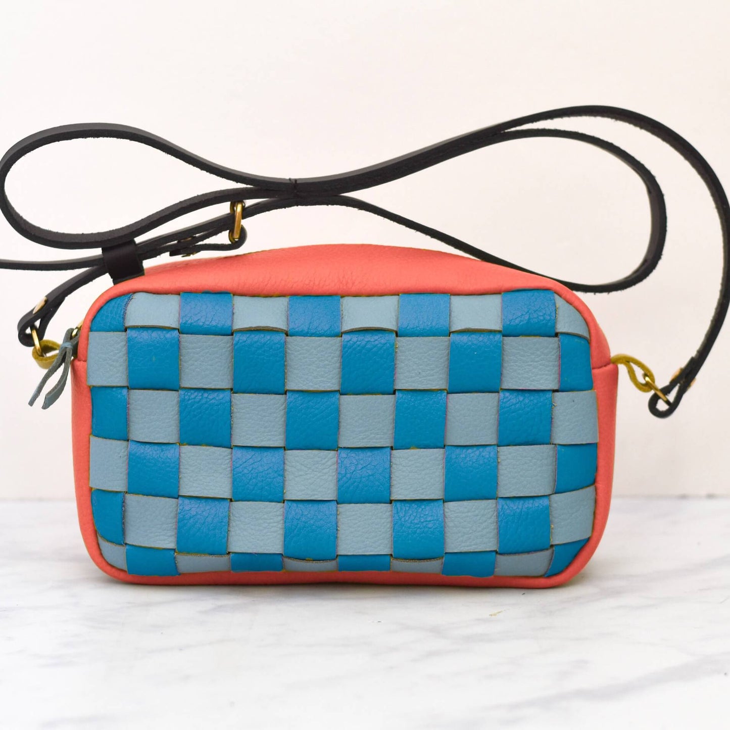 Woven crossbody bag with blue and gray pattern on a white background
