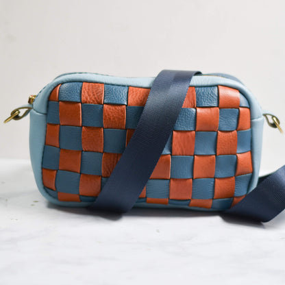 Woven handbag with blue and brown pattern on a white background