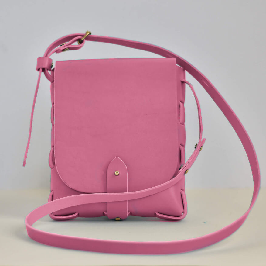 Pink leather crossbody bag on a light gray background made from a kit