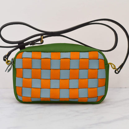 Woven crossbody bag with green, orange, and blue pattern on a white background