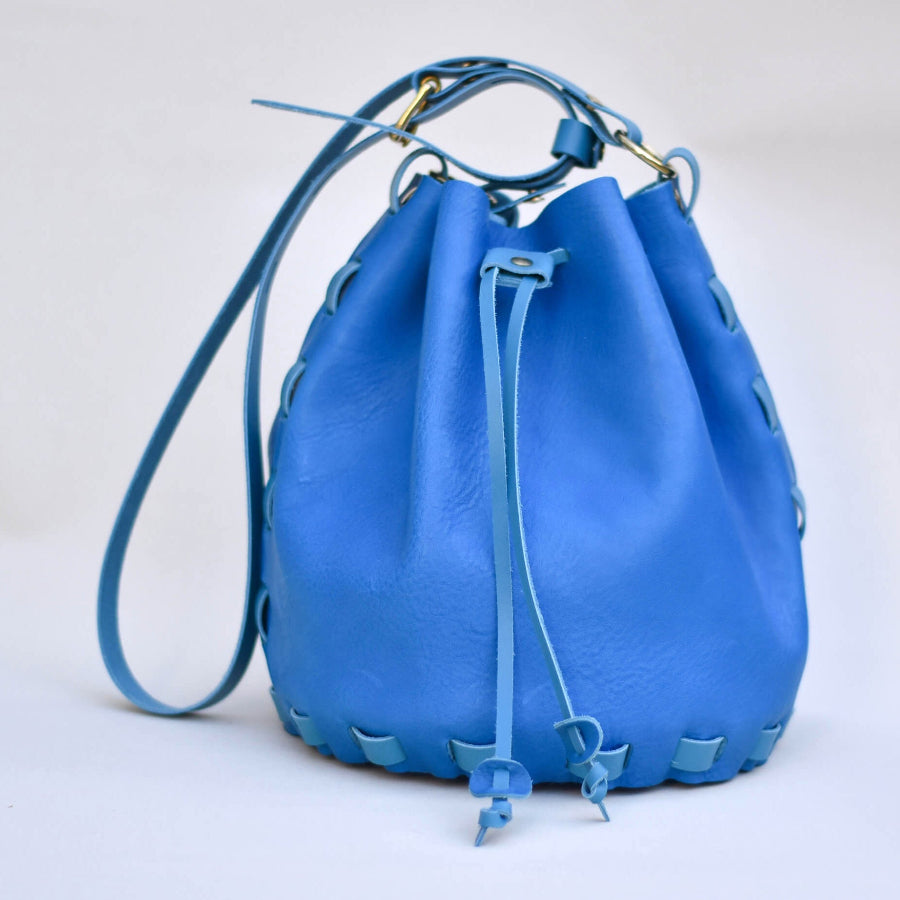 A mid blue leather bucket bag with a drawstring made from a DIY kit