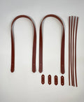 Set of brown leather straps and leather thonging for bag makers on a white background