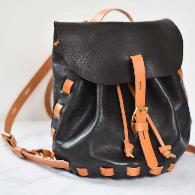 black and tan leather backgpack on white background