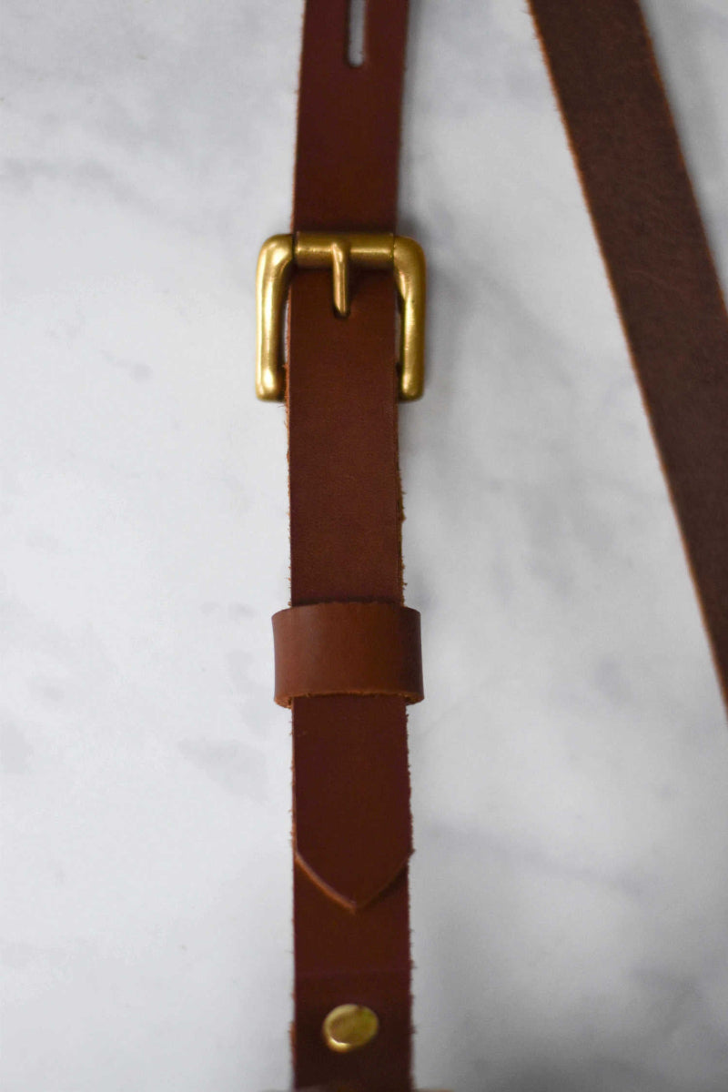 close up of buckle detail of bag strap in brown